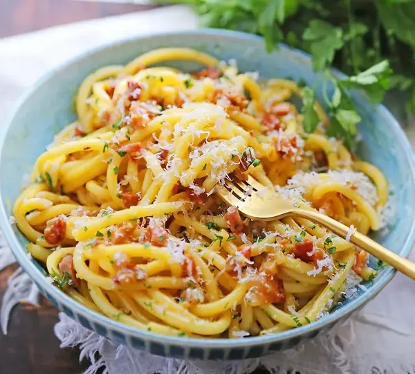 Learn how to make the authentic Bucatini Carbonara, a classic Italian pasta dish with eggs, cheese, and pancetta. Try it now!